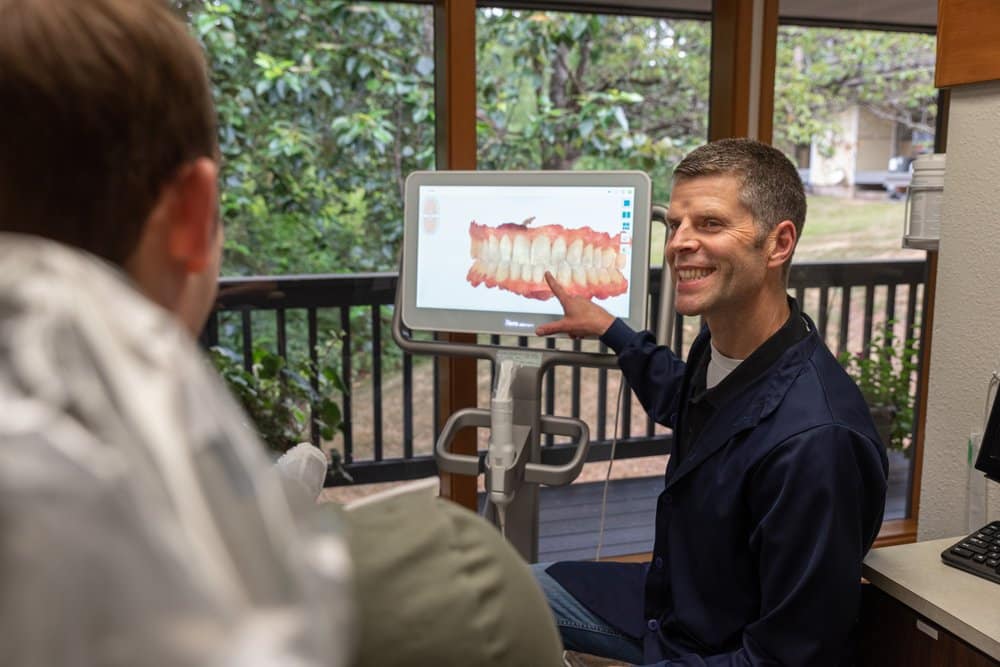 Dr. Manson, a Kirkland dentist, showing a patient their 3D scans for crowns